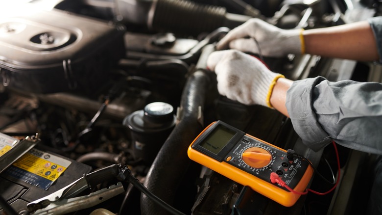 Closeup,Image,Of,Mechanic,Using,Multimeter,When,Checking,Car,Engine